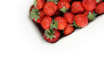 Freshly harvested ripe garden strawberries in recycled paper food container on a white background, top view close-up. Copy space.