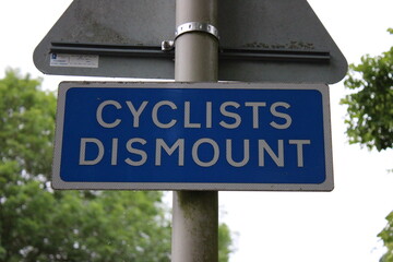 Blue Cyclists Dismount road sign UK