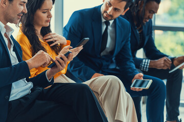 A group of diversity businessman sitting while sharing their data by using smart phone in side...