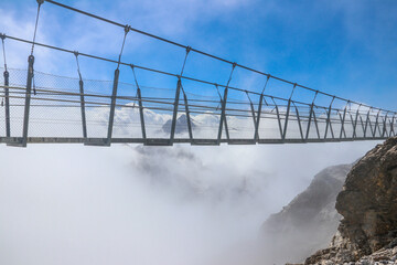 Titlis suspension bridge of steel crossing the peak on top of Titlis glacier in the Uri Alps, Engelberg, Switzerland. Highest suspension bridge in Europe - obrazy, fototapety, plakaty