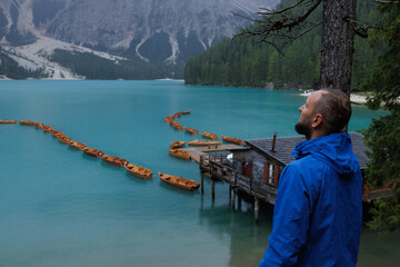 Fototapeta premium A man enjoying the wonderful atmosphere of a beautiful lake set in the Alps.