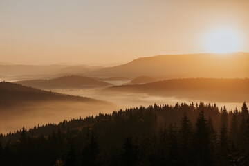 Obraz premium As the first light of dawn gently kisses the horizon, the mountains awaken in a symphony of natural beauty.