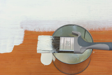 Pincel preparado para pintar, sobre la lata de pintura, visto desde arriba