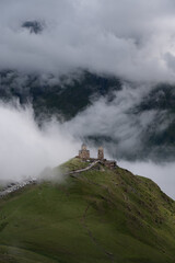 A view of the iconic Trinity Church in Stepantsminda surrounded by low clouds