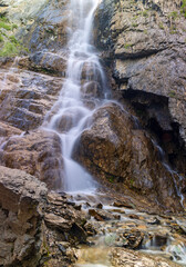 waterfall between brown rocks in Altai mountains