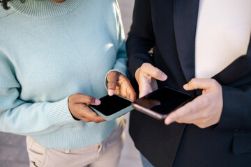 Hands of two friends typing on the phone