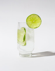 Glass of water with lemon slices and ice cubes isolated on a white background