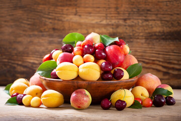 bowl of fresh ripe fruits on wooden table