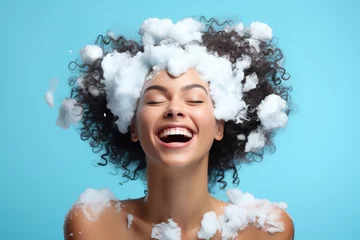Poster portrait beautiful model girl with big soap foam on head in hair on solid blue background, hygiene, Shampoo, hair treatment and soap, bathing time © Jim1786