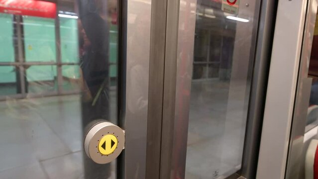 Prague,Czech Republic,August 4,2023. Footage inside the subway carriage. The sliding doors close: we are about to leave for a new ride. The yellow door opener button is highlighted.