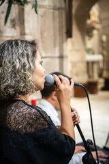 Close up of a caucasian woman holding a microphone during a musical performance in the interior of...