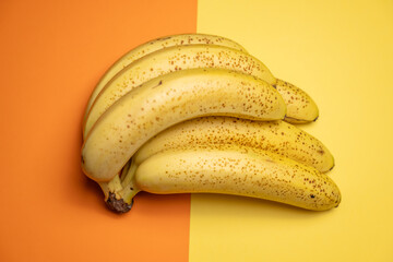 régime de bananes sur un fond coloré orange et jaune