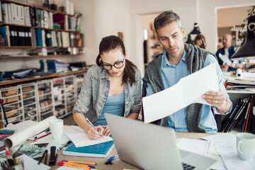 Young man and woman working together on a project in a startup company office