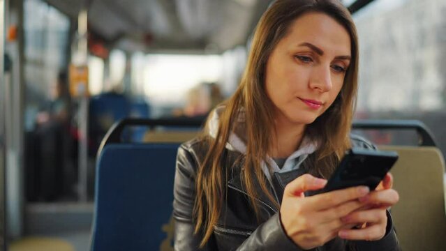 Public transport. Woman in tram using smartphone, slow motion