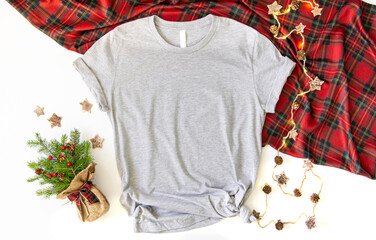 Flat lay mockup of gray tshirt with Christmas accessories. X mas gey 3001 t shirt top view and...