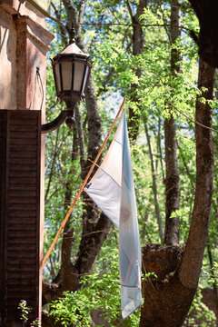 an old lamp post in a brick wall and a flag of argentina