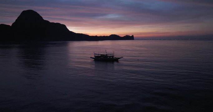 Sunset drone view above the sea of a Filipino traditional boat, El Nido, Philippines