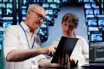 Cloud computing business executives running analysis on supercomputers used for managing databases,...