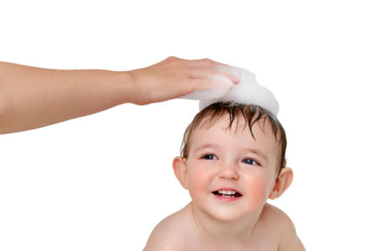 A mother washes a child with soap suds, isolated on a white background. Mom s hand washes baby head with shampoo in bath, isolated on a white background. Kid aged one year and three months