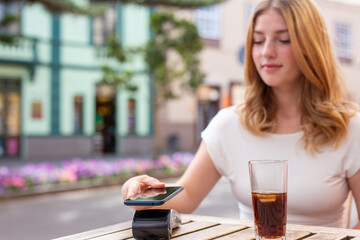 woman paying with her smart phone, NFC technology concept