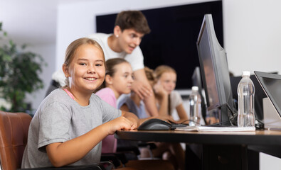 Portrait of female schoolgirl at computers in shool computer class