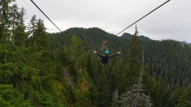 Adventure Woman riding on a Zipline. Extreme Fun Activity.