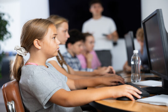 Concerned preteen girl working with computer programs with interest in training room