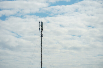 Obraz premium New GSM antennas on a high tower against a blue sky for transmitting a 5g signal are dangerous to health. Radiation pollution of the environment through cell towers. The threat of extinction