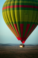 Obraz premium Hot balloon flying at sunset over the Atlas Mountains in the desert of Morocco 