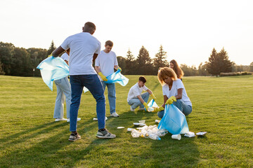multiracial group of people volunteers with garbage bags collect garbage and plastic in the park, team of students clean