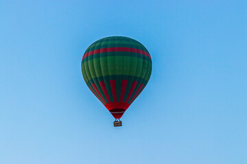 Hot balloon flying at sunset over the Atlas Mountains in the desert of Morocco 