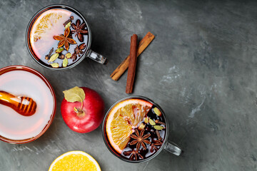 Two cups of mulled wine with spices on dark concrete background. Top view