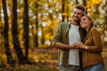 Happy, young couple in love hugging and walking in the forest