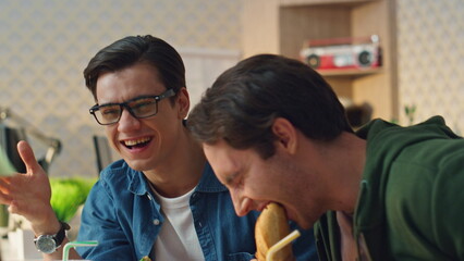 Laughing guys reacting emotionally at lunch break close up. Designers having fun