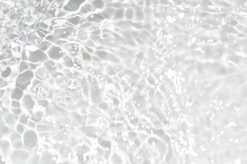 Defocus blurred transparent gray colored clear calm water surface texture with splashes reflection. Trendy abstract nature background. Water waves in sunlight with copy space. Blue watercolor shine.