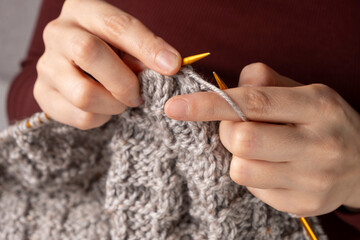 Close-up of hands knitting. Process of knitting.