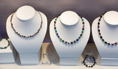 Colorful necklaces, earrings and bracelets from semiprecious stones in jewelry store window