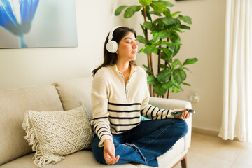 Relaxed woman practicing mindfulness meditation with headphones