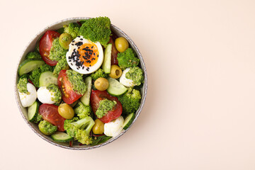 Delicious salad with pesto sauce in bowl on beige table, top view. Space for text