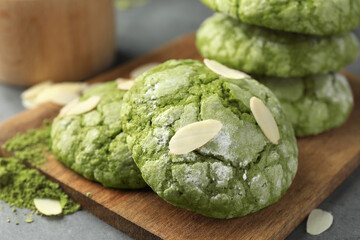 Tasty matcha cookies, almond flakes and powder on grey table, closeup