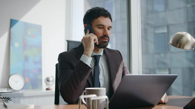 Displeased entrepreneur complaining smartphone conversation at office close up. 
