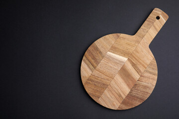 One wooden board on black background, top view. Space for text