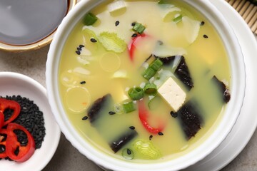 Bowl of delicious miso soup with tofu on table, top view