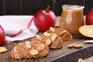 Pieces of fresh apple with peanut butter on table, closeup