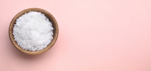 Bowl with sea salt on light coral background, top view. Banner design with space for text