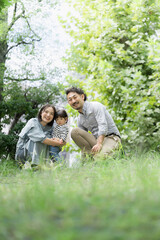 Fototapeta premium 公園で遊ぶ仲良し3人家族 上下にコピースペースあり