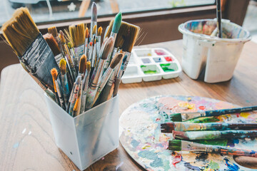 Obraz premium Close-up of several brushes used for painting placed on a table.