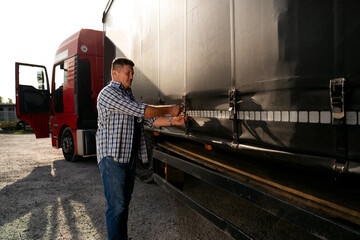 Truck driver securing his cargo, checking trailer 