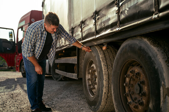 Truck Driver Checking Tires Before Road 