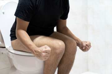 Sitting on toilet with suffering from constipation or hemorrhoid.  Feels uncomfortable in his stomach and is constipated in the toilet. suffering from diarrhea, cystitis. Stomach pain during PMS. - obrazy, fototapety, plakaty